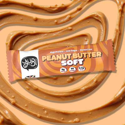 YuBi Peanut Butter Soft protein bar on a swirl of peanut butter
