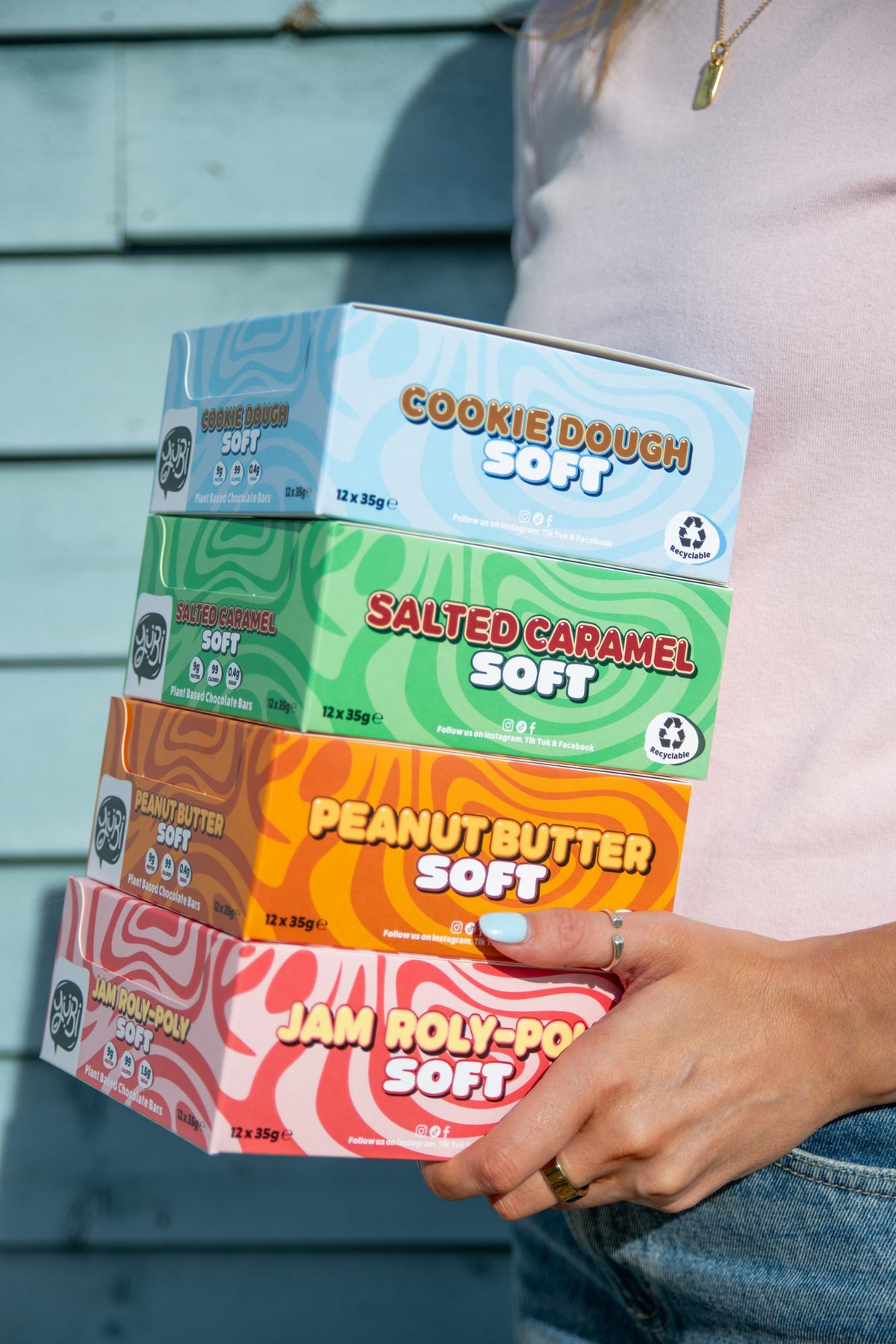 Holding a stack of YuBi Soft boxes: Cookie Dough, Salted Caramel, Peanut Butter and Jam Roly-Poly